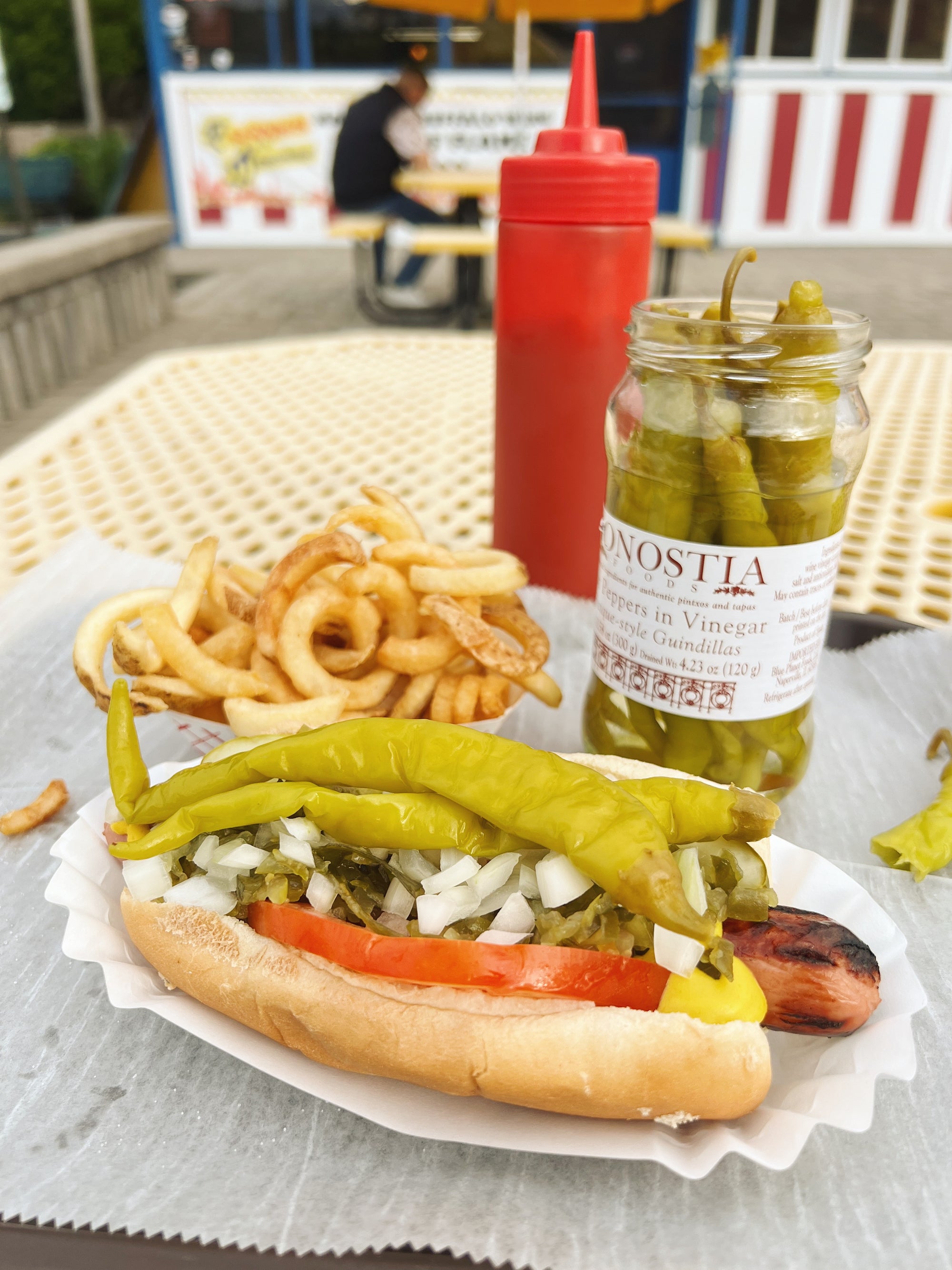 Guindilla peppers on a hot dog with curly fries - Donostia Foods